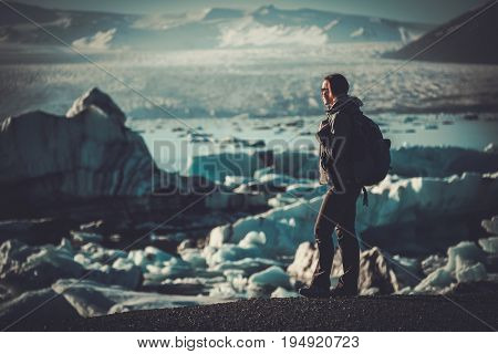 Woman explorer lookig at Jokulsarlon lagoon, Iceland.