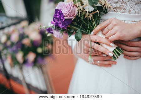 Stylish beautiful bride holds a wedding bouquet in hands