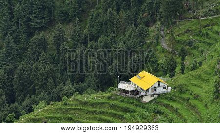House with Yellow Roof Situated in Hills