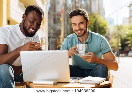 Time for us. Charismatic lively original man inviting his friend having a cup of coffee in their favorite place while sharing his idea with him