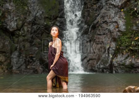 Daily life of rural women in AsiaWas bathing in a waterfall