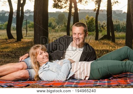 young couple in love in park on blanket