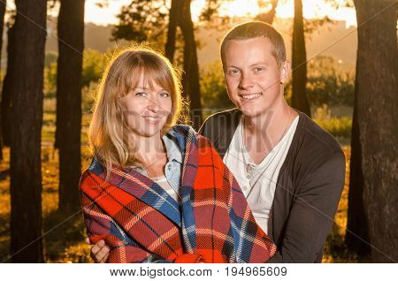young loving couple standing hugging in the woods