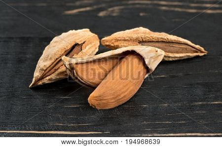 Wild uzbek inshell almonds on wooden background