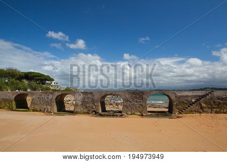 Old stone bridge on El Sardinero beach in Santander Spain