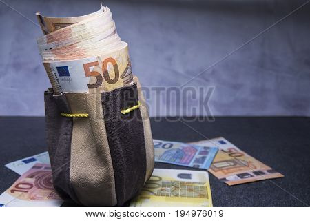 Fifty euros in the pouch and banknotes on the table