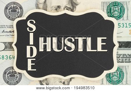 Making money with your side hustle Side Hustle text on chalkboard on USA twenty dollar bills