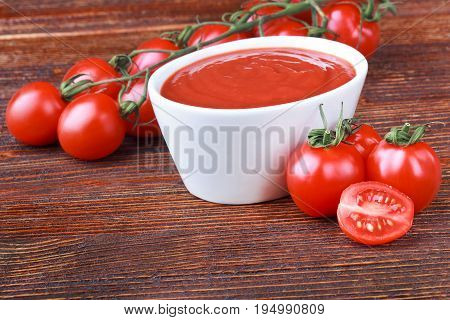 Tomato paste and ripe tomatoes on an old brown wooden table(selective focus).