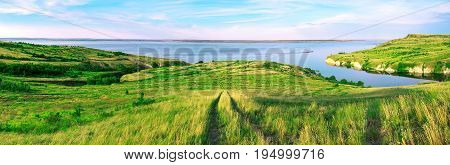 Scenic sea view from top of hills. Beautiful summer background. Amazing landscape with yellow meadows green trees blue sky steep cliffs and picturesque bay. Panoramic photo. Camping rest relax.