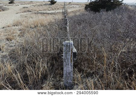Wooden Fence Stretching Across Dunes At Scusset Beach State Reservation In Sandwich, Massachusetts
