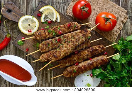 Delicious Lula Kebab On A Wooden Table. Chopped Meat On Wooden Skewers, Grilled. Eastern Cuisine. To