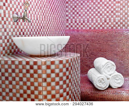 Traditional Turkish Hamam With Stone Walls, Sink And Stack Of  Towels