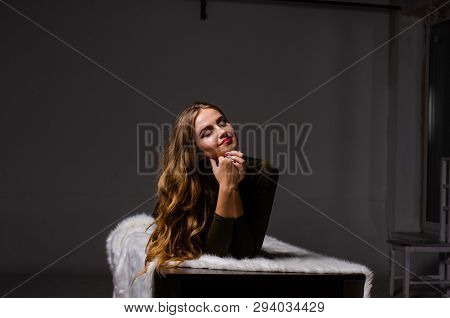 Beautiful Dancer. Girl Model. The Girl Sits In A Hat And Sits On A Table. Girl In A Beautiful Underw