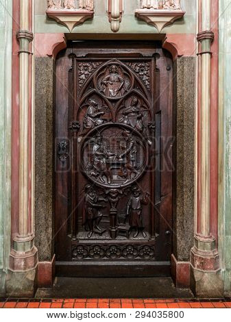 MALBORK, POLAND - 15 AUGUST, 2013: Old wooden doors with relief - Teutonic Malbork castle, Poland. Malbork castle is the largest brick fortress in the world