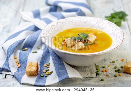 Soup Of Split Peas And Smoked Ribs With Croutons In A Plate On An Old Wooden Table, Selective Focus.