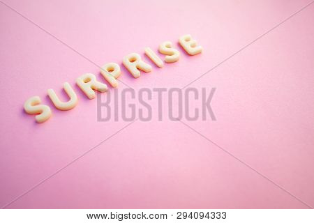 Surprise Word Written In Voluminous White Letters On A Beautiful Pink Background. Greting Card