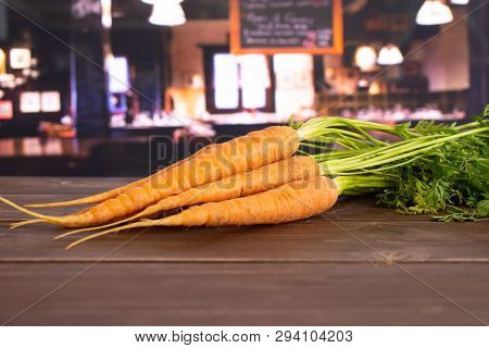 Group Of Five Whole Fresh Orange Carrot Bunch With Greens In A Restaurant