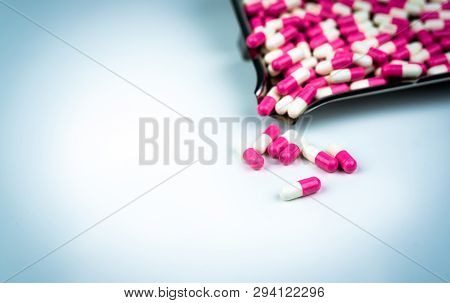 Pink And White Antibiotic Capsule Pills And Drug Tray On White Background. Global Healthcare Concept