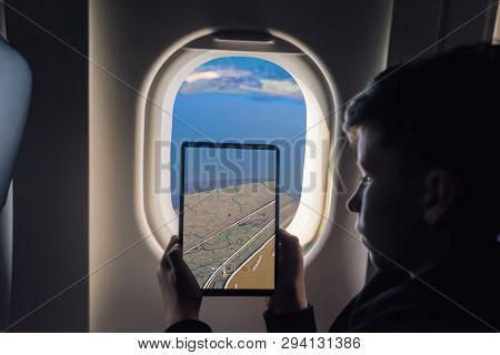 Caucasian Boy Using Tablet Pc For Taking Picture Through Plane Window Salt Ponds In Don Edwards. San