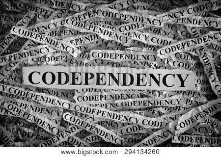 Codependency. Torn Pieces Of Paper With The Words Codependency. Concept Image. Black And White. Clos
