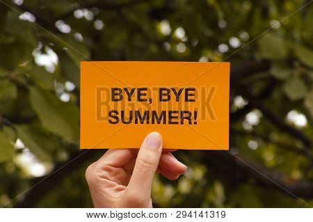 Bye, Bye Summer! Hand Holds Yellow Piece Of Paper That Says Bye, Bye Summer!. Close Up.