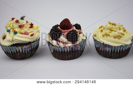 Various Cupcakes With Cream On A White Background. Copy Space