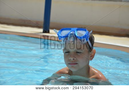 Teenager Boy Wearing Mask Swimming In The Pool. Happy Holiday Concept. Cute Happy Little Boy Swimmin