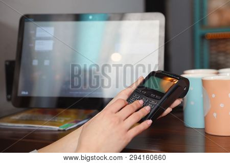 Woman Using Credit Card Machine For Non Cash Payment In Cafe, Closeup. Space For Text