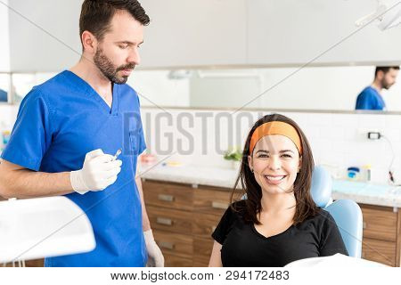 Good Looking Woman Smiling While Surgeon Using Lip Injectable On Her To Help Lips Look Plumper And F