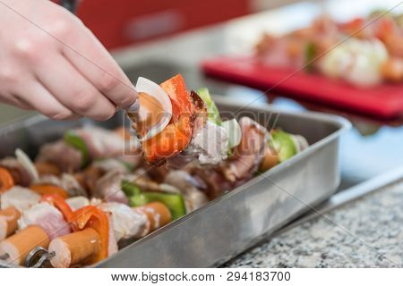Cook Prepares Skewers In Pan For Grilling - Close-up