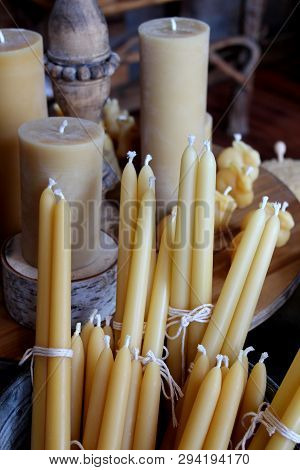 Arrangement Of Long Tapered Other Shapes And Sizes Of Bees Wax Candles On Display In Country Home.