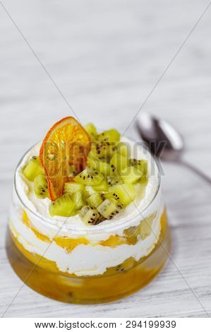 Tropical Fruits Trifle, Appetizing Cold Dessert Of Sponge Cake, Kiwi And Peach Slices Covered With L