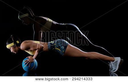 one mixed race woman exercising fitness exercises isolated on black background with lightpainting effect multiple exposures