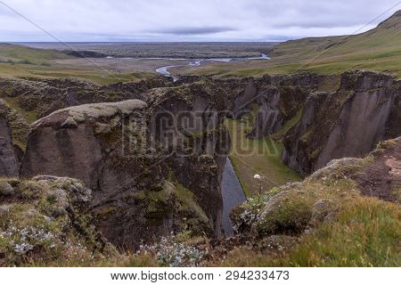 Deep Gorge, At The Bottom Of Which Flows A Mountain River And Goes Into A Lava Field Covered With Mo