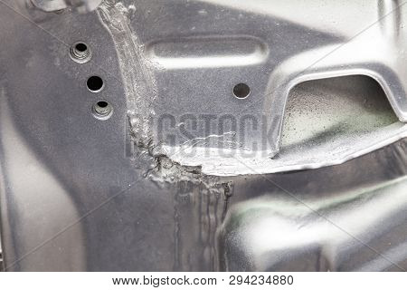 Close-up On The Weld Connecting The Metallic Parts Of A Car Of Silver Color Smeared With Sealant And