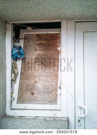 Boarded Up Window Next To Door Of A House
