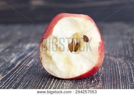 Bitten Off A Piece Of Red Ripe Apple With Black Bones, Closeup