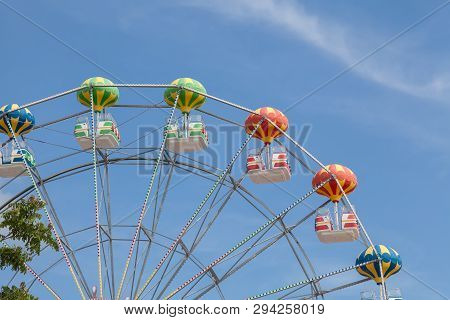 Close Up Of Colorful Ferris Wheel. Blue Sky