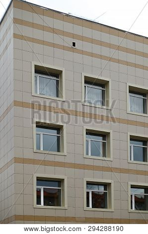 The Facade Of A Multi-storey Clinical Building. The Walls With Many Windows Are Finished With Plasti