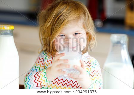 Adorable Toddler Girl Drinking Cow Milk For Breakfast. Cute Baby Daughter With Lots Of Bottles. Heal