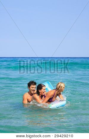 Gruppo di tre amici - uomo e donna - sulla spiaggia avendo un sacco di divertimento in vacanza in Grecia
