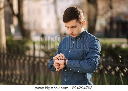 Handsome Business Man Look At The Watch In The City. Man Ajust The Exact Time On The Watch