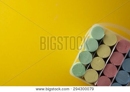 Abstract Colorful Chalks Over Yellow Background With Copy Space. Education Template. Creative Childh