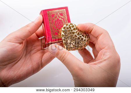 Hand Holding Heart Shape  And Islamic Holy Book Quran