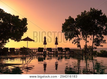 Beautiful Sunset On Tropical Island Koh Phangan In Thailand. With Sunbed Trees In Front