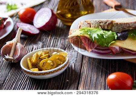 Sandwich With Bacon, Cheese, Garlic, Jalapeno Pepper And Herbs On A Plate, On A Wooden Background