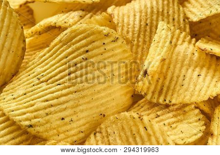 Background Of Juicy Corrugated Rounded Potato Chips Close-up