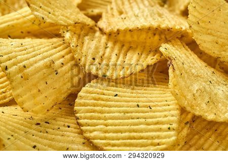 Background Of Juicy Corrugated Rounded Potato Chips Close-up