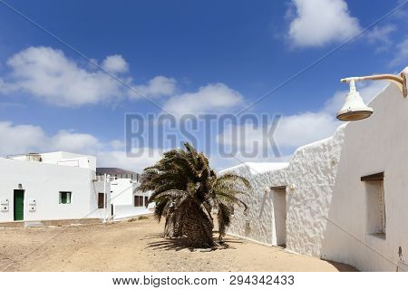 Empty Street With Sand And White Houses And A Palm Tree In Caleta De Sebo On The Island La Graciosa 