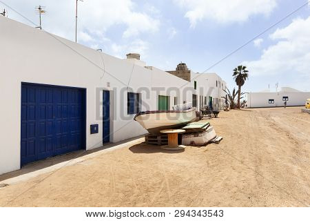 Empty Street With Sand And White Houses And A Boat In Caleta De Sebo On The Island La Graciosa Of La